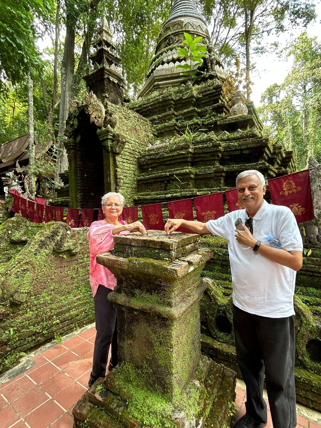 Guests at the moss-covered chedi of Wat Pha Lat